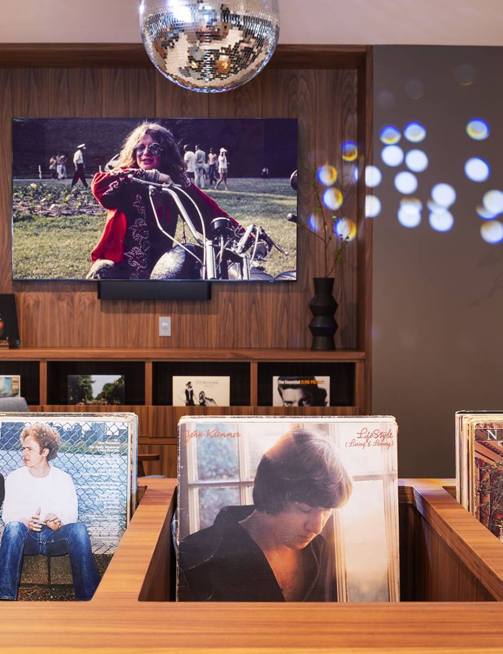 Groove lofts by Sherman Associates in Minneapolis, Minnesota Vinyl Lounge with records, TV playing music video, and disco ball.