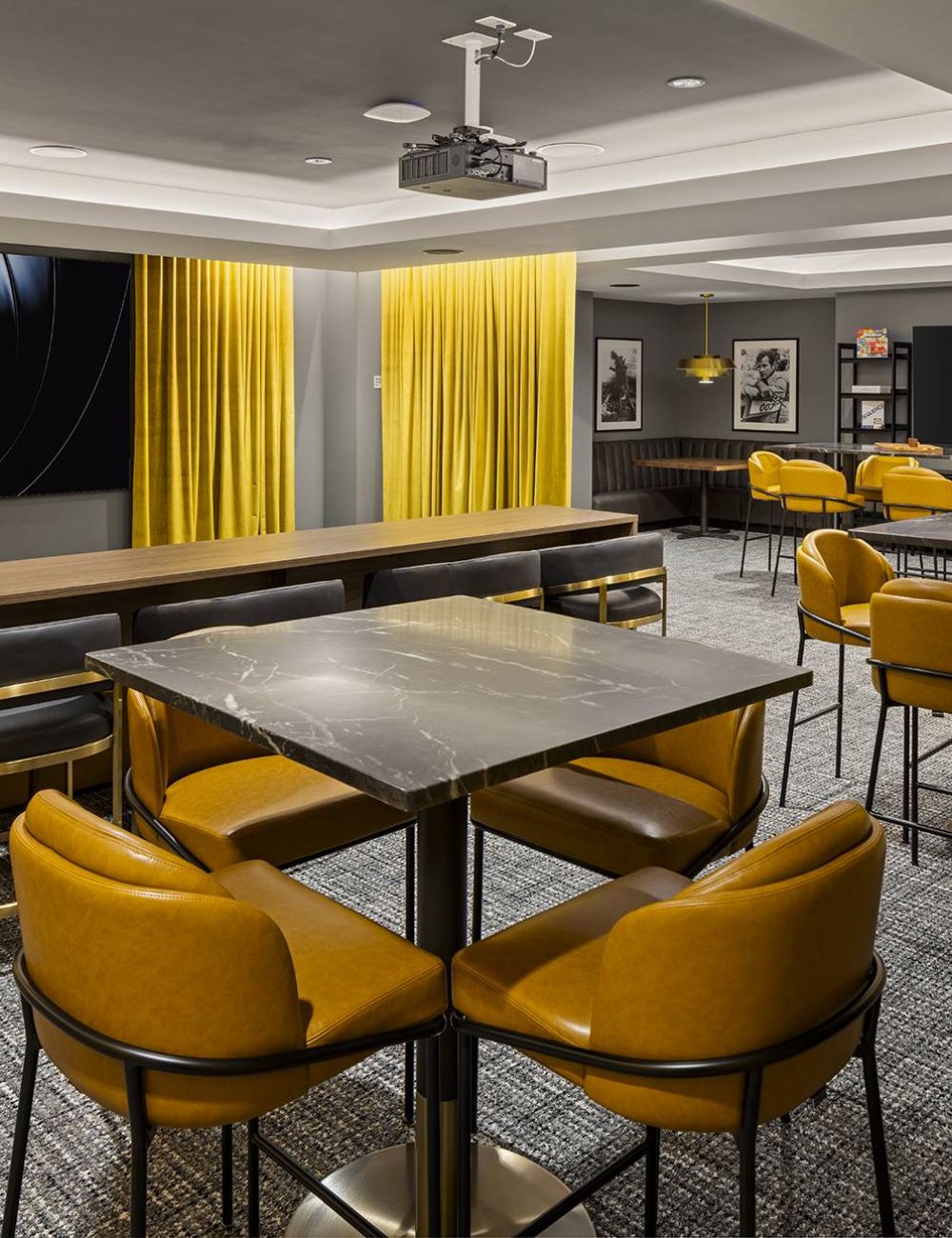 Groove lofts by Sherman Associates in Minneapolis, Minnesota lounge area with seating, a bar, and movie projector.